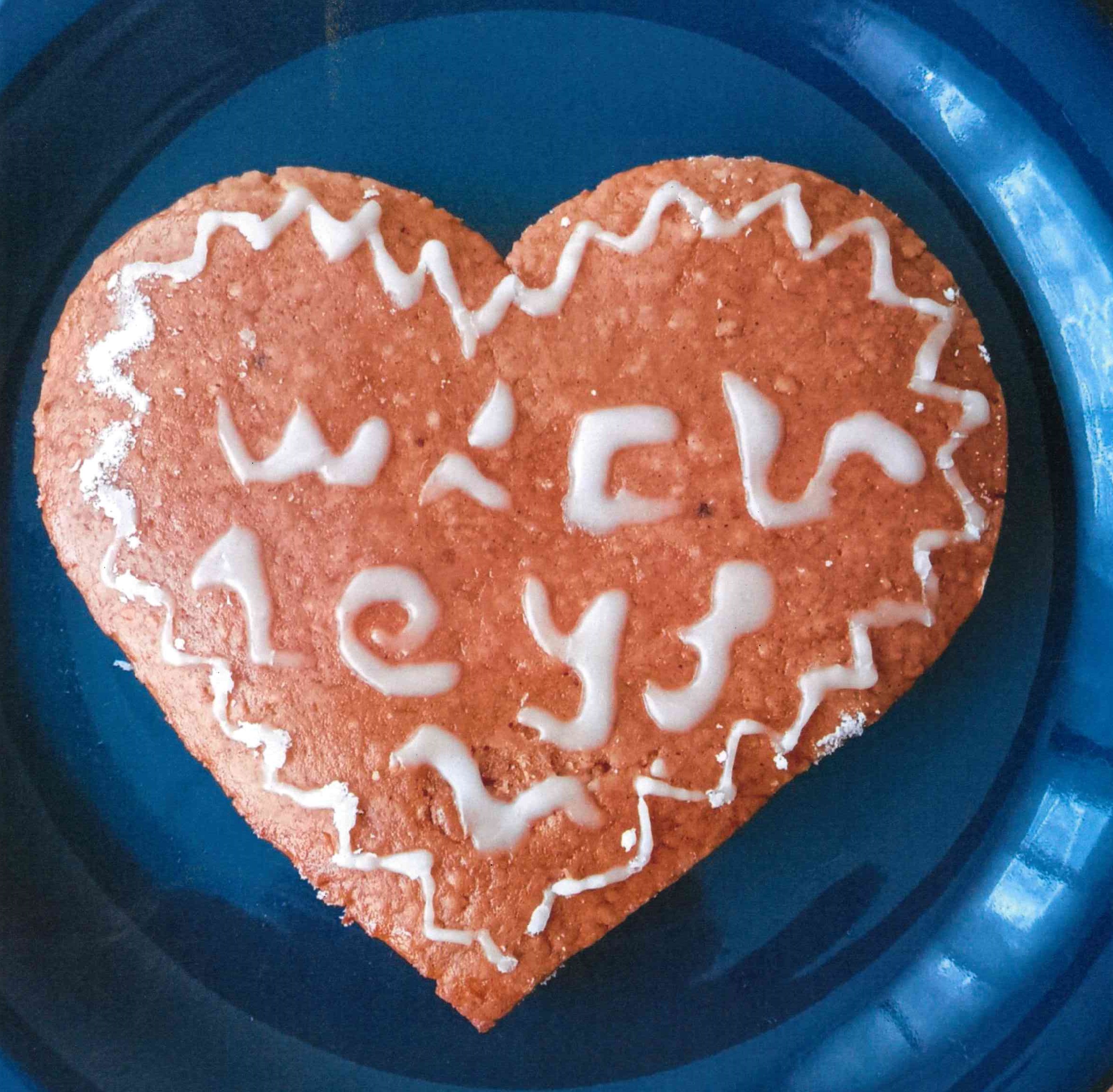 Photo d'un pain d'épices en forme de cœur avec des inscriptions paléographiques en sucre glace