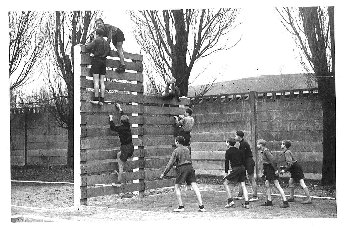 Une dizaine d'enfants en séance de sport, ils doivent grimper pour passer un obstacle