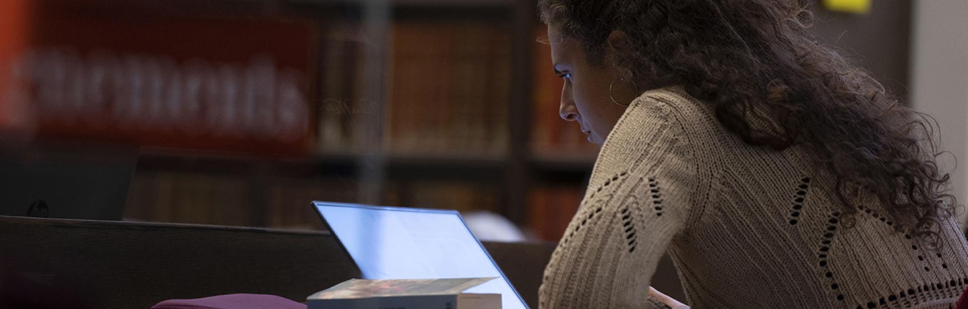 Une élève à la bibliothèque travaillant sur son ordinateur