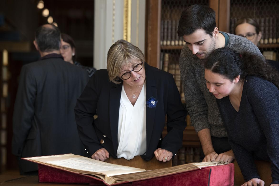 Des élèves du cursus archiviste paléographe présentent un ouvrage à Sylvie Retailleau